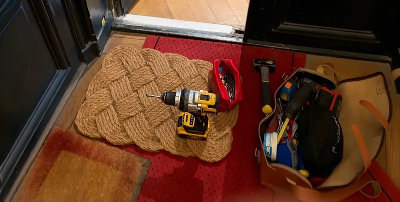 Perceuse et outils de serrurier posés devant une porte d'entrée, photo d'une intervention de France Serrures