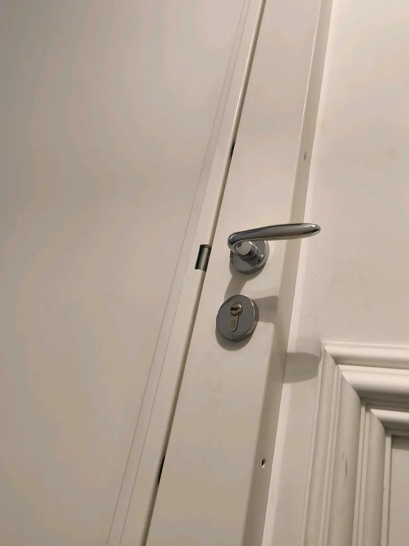 Porte blanche à moulures avec poignée et cylindre, photo d'une intervention de France Serrures