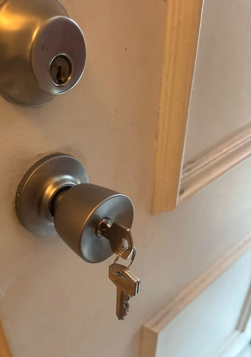Serrure à bouton et verrou à cylindre posés sur une porte d'entrée, photo d'une intervention de France Serrures